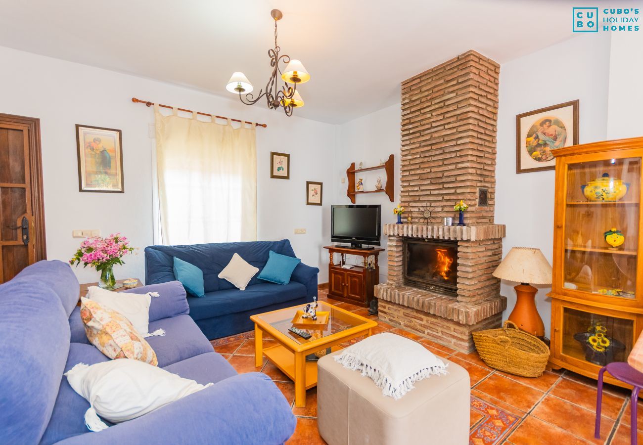 Salón de esta casa con chimenea en Coín