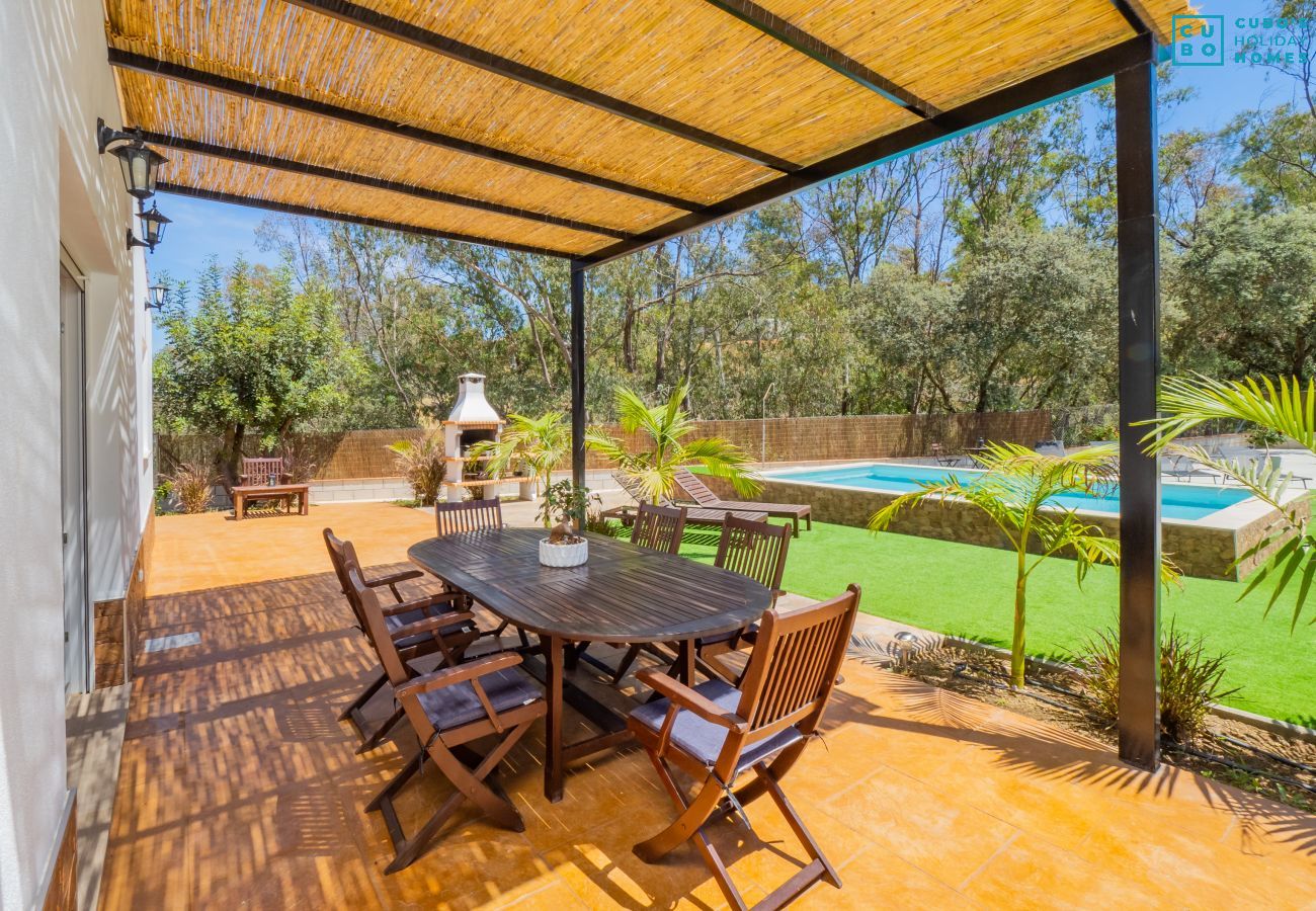 Porche extérieur du logement avec vue sur la piscine.